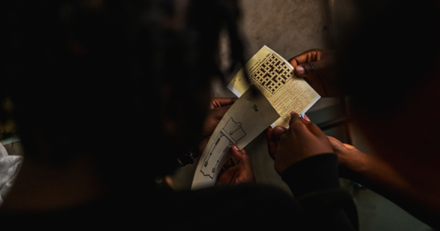 Players solving a coded puzzle at Houdini’s Escape Rooms